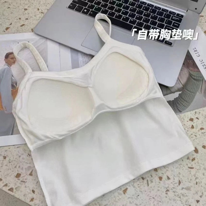 A Crop Top Women Sexy Sleeveless Top with built-in bra cups is displayed on a table beside a laptop, magazine, and photo—ideal for summer. Chinese text is visible in the upper right corner of the image.